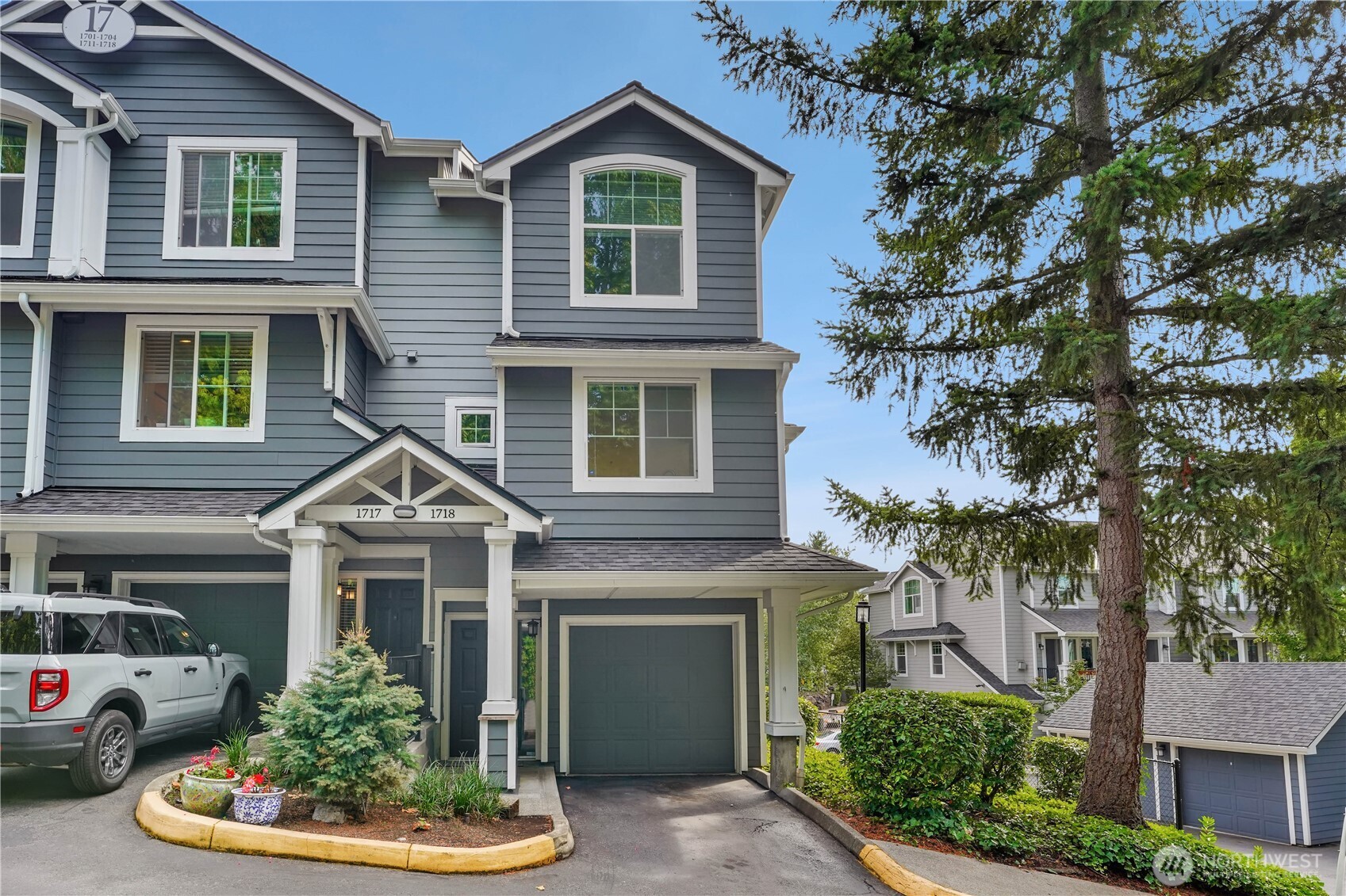 16125 Juanita Woodinville Way Northeast, Unit 1718 Bothell, WA 98011 - Photo 1 of 1 a front view of a house with a yard and garage