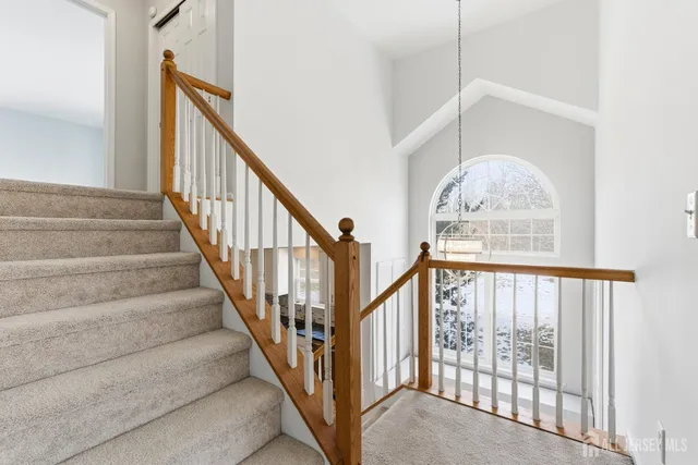 a view of staircase with lots of frames on wall and a window