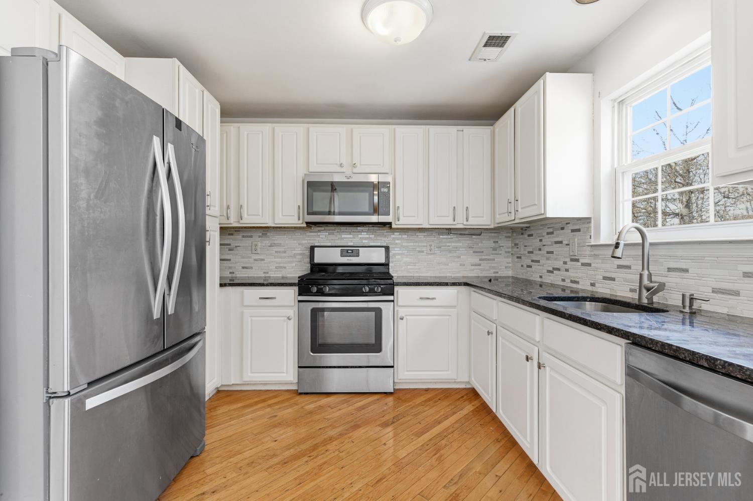 12 Rondell Lane Old Bridge, NJ 08879 - Photo 9 of 34 a kitchen with white cabinets and stainless steel appliances