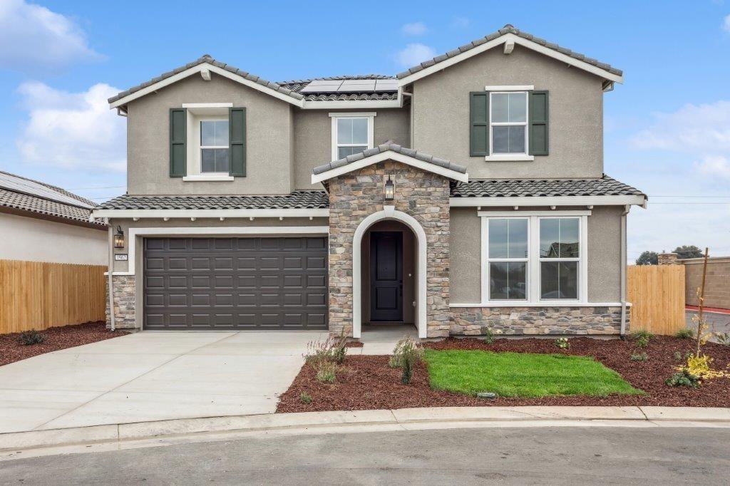 a front view of a house with a garden and garage