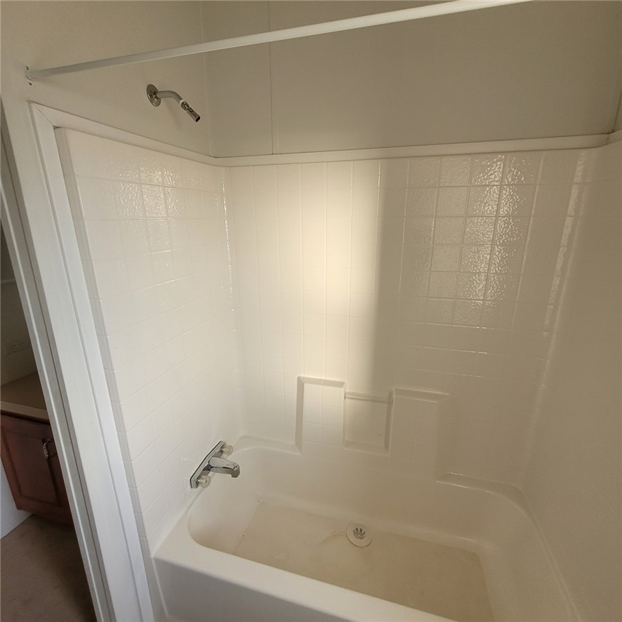 9732 2nd Street Chloride, AZ 86431 - Photo 5 of 28 The bathroom features a white bathtub and shower combination with a bright white tiled surround and a chrome showerhead