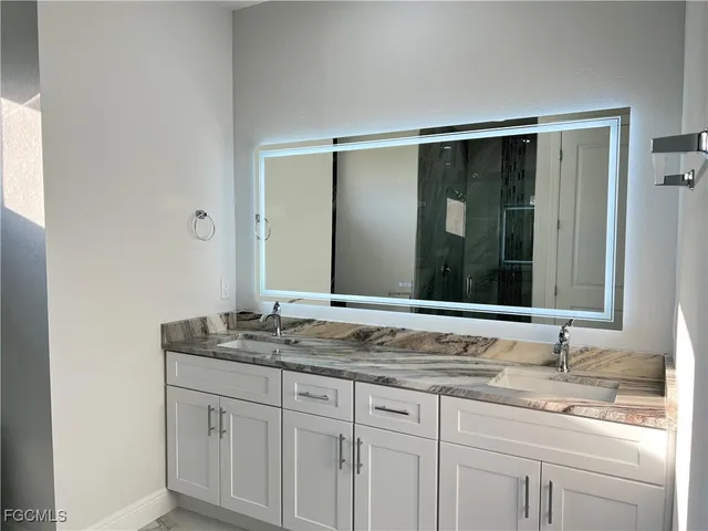 a bathroom with a granite countertop sink double and mirror