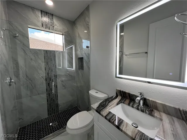 a bathroom with a sink a toilet and shower