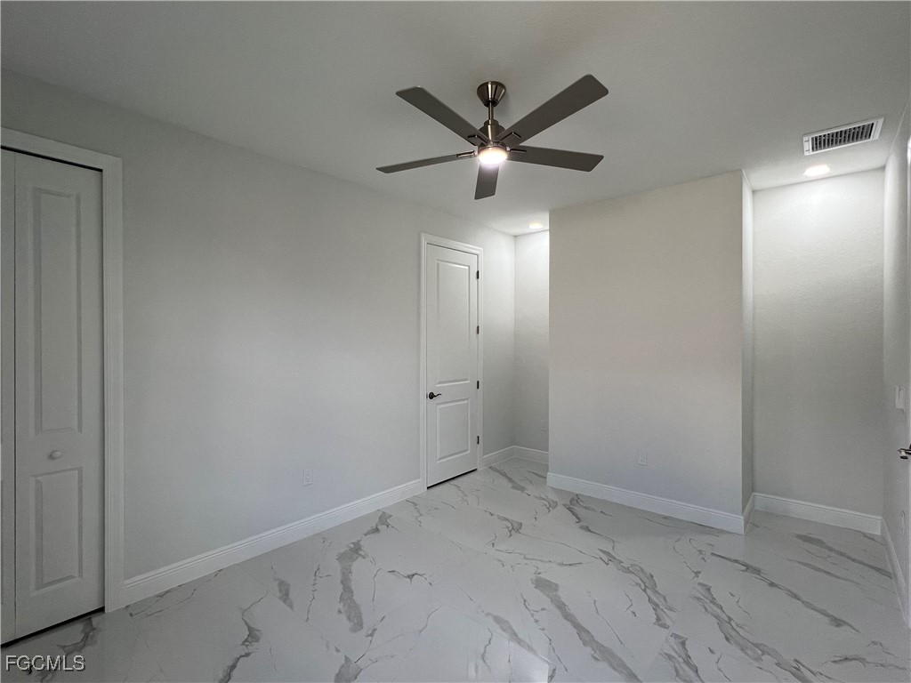 1010 Angelo Avenue Lehigh Acres, FL 33971 - Photo 23 of 34 a view of a hallway with a chandelier fan