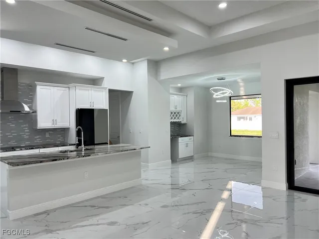 a kitchen with stainless steel appliances granite countertop a sink and a refrigerator