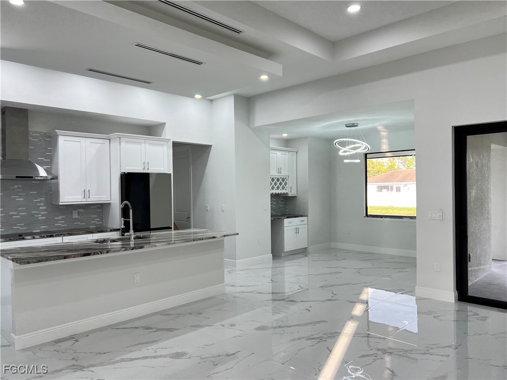 1010 Angelo Avenue Lehigh Acres, FL 33971 - Photo 5 of 34 a kitchen with stainless steel appliances granite countertop a sink and a refrigerator