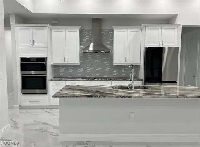 a kitchen with granite countertop white cabinets and stainless steel appliances