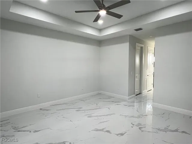 an empty room with a ceiling fan and window
