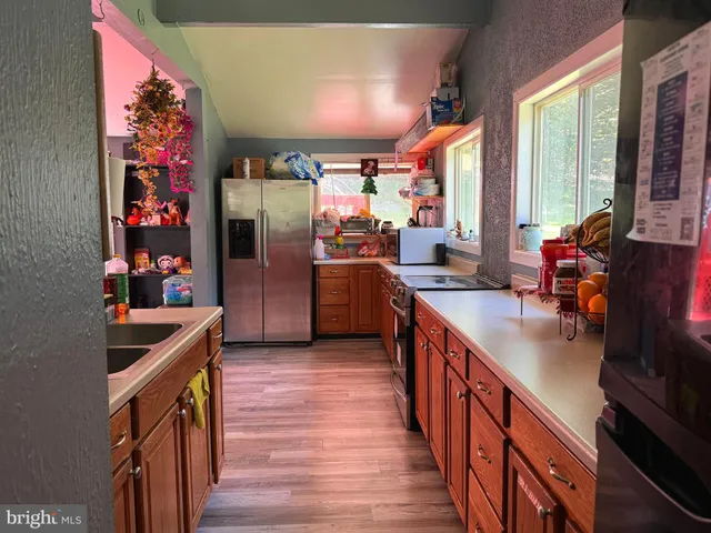 a kitchen with stainless steel appliances granite countertop sink stove top oven and cabinets