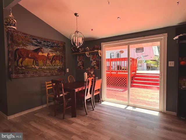 a dining room with wooden floor table and chairs