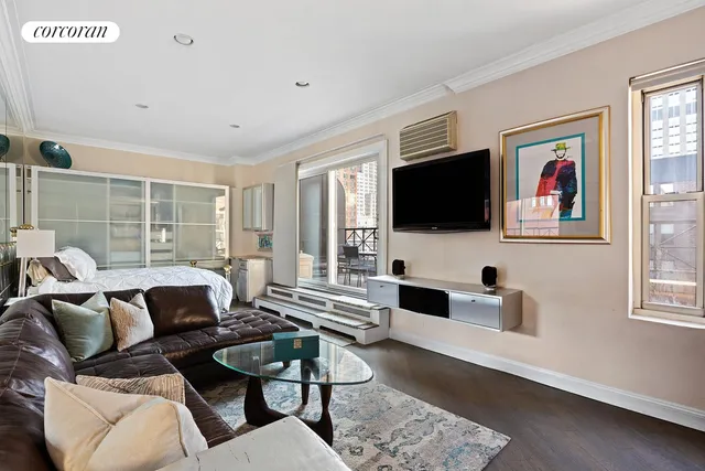 a living room with furniture a flat screen tv and a window