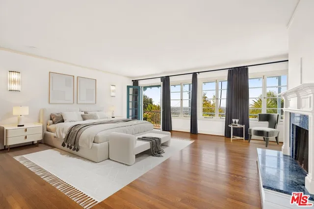 a spacious bedroom with a balcony a bed and a large window