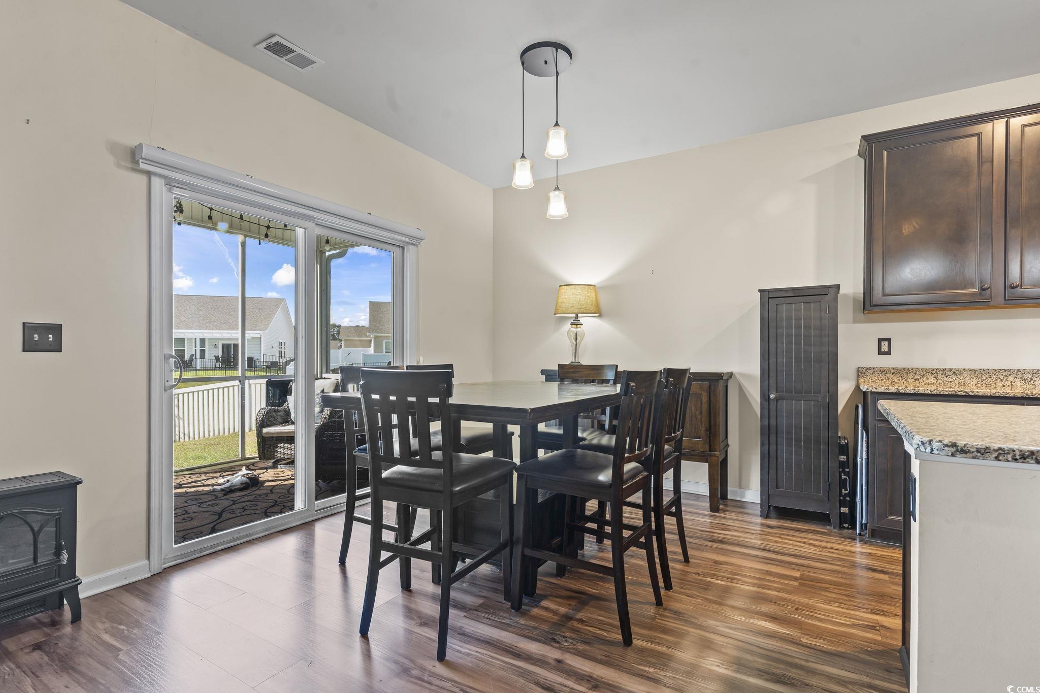 256 Copper Leaf Drive Myrtle Beach, SC 29588 - Photo 11 of 40 Dining area featuring dark wood-type flooring and a wood stove