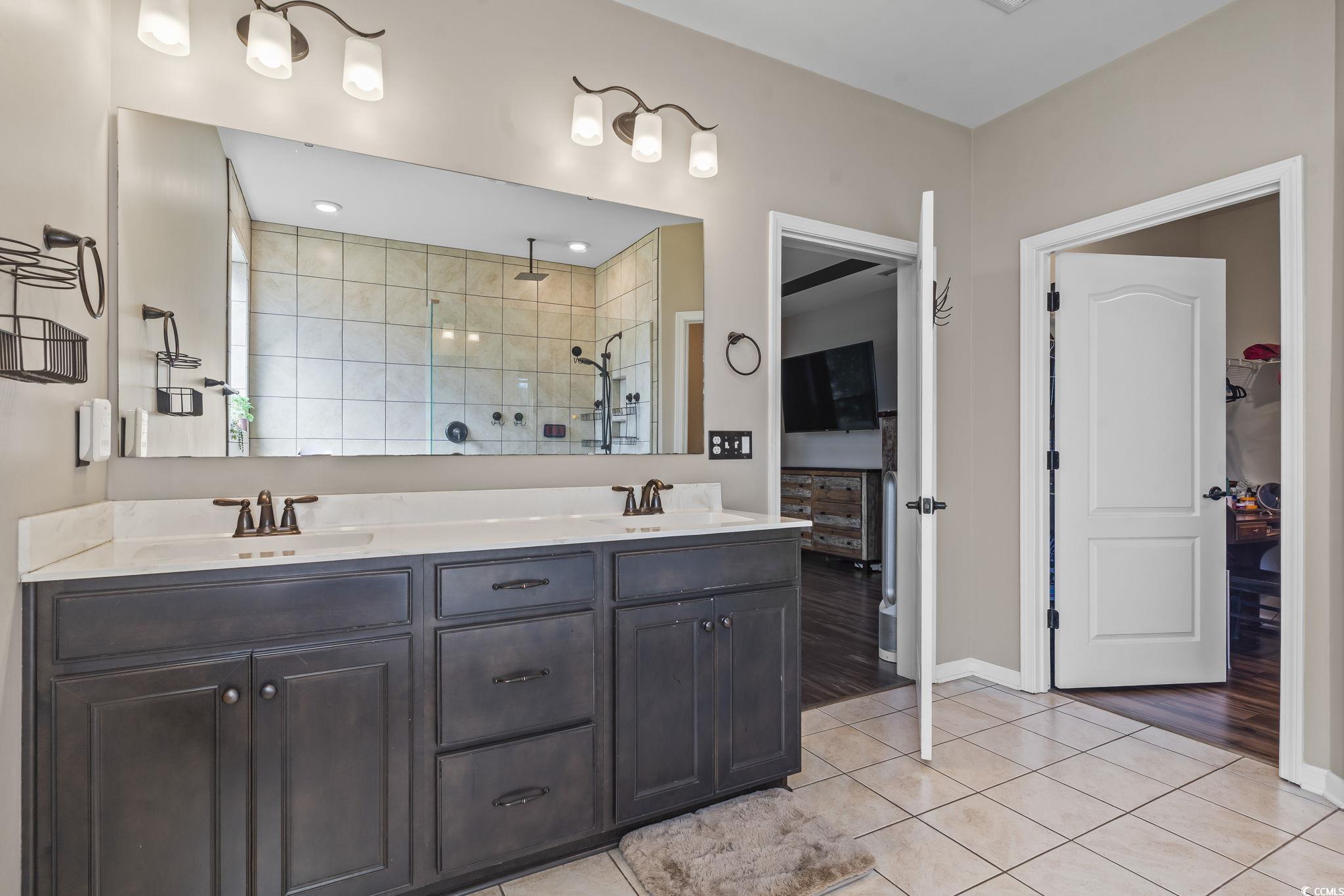 256 Copper Leaf Drive Myrtle Beach, SC 29588 - Photo 16 of 40 Primary bath with light tile patterned flooring, a stall shower, double vanity, and a spacious closet