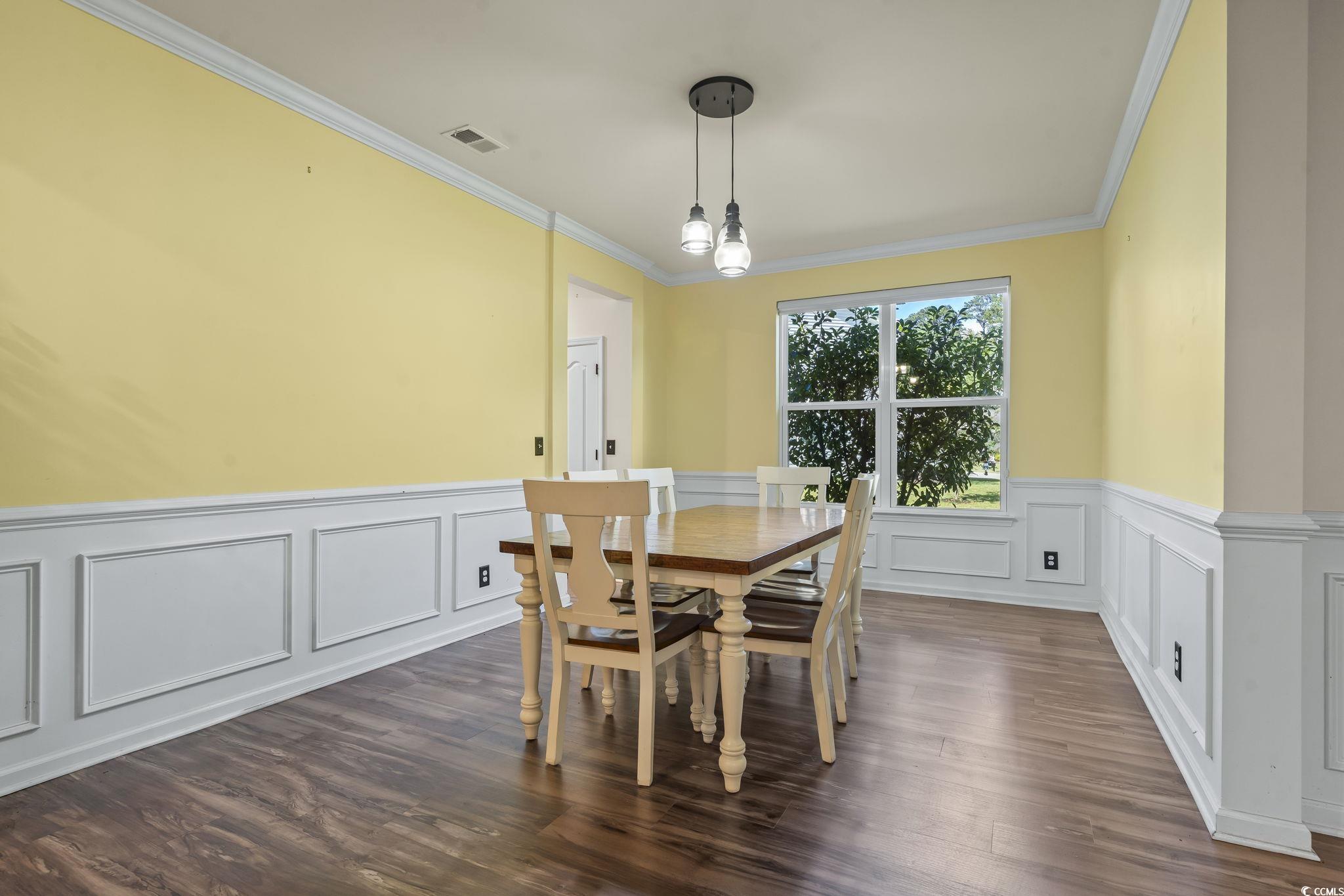 256 Copper Leaf Drive Myrtle Beach, SC 29588 - Photo 23 of 40 Dining room featuring ornamental molding, a wainscoted wall, a decorative wall, and dark wood-style floors