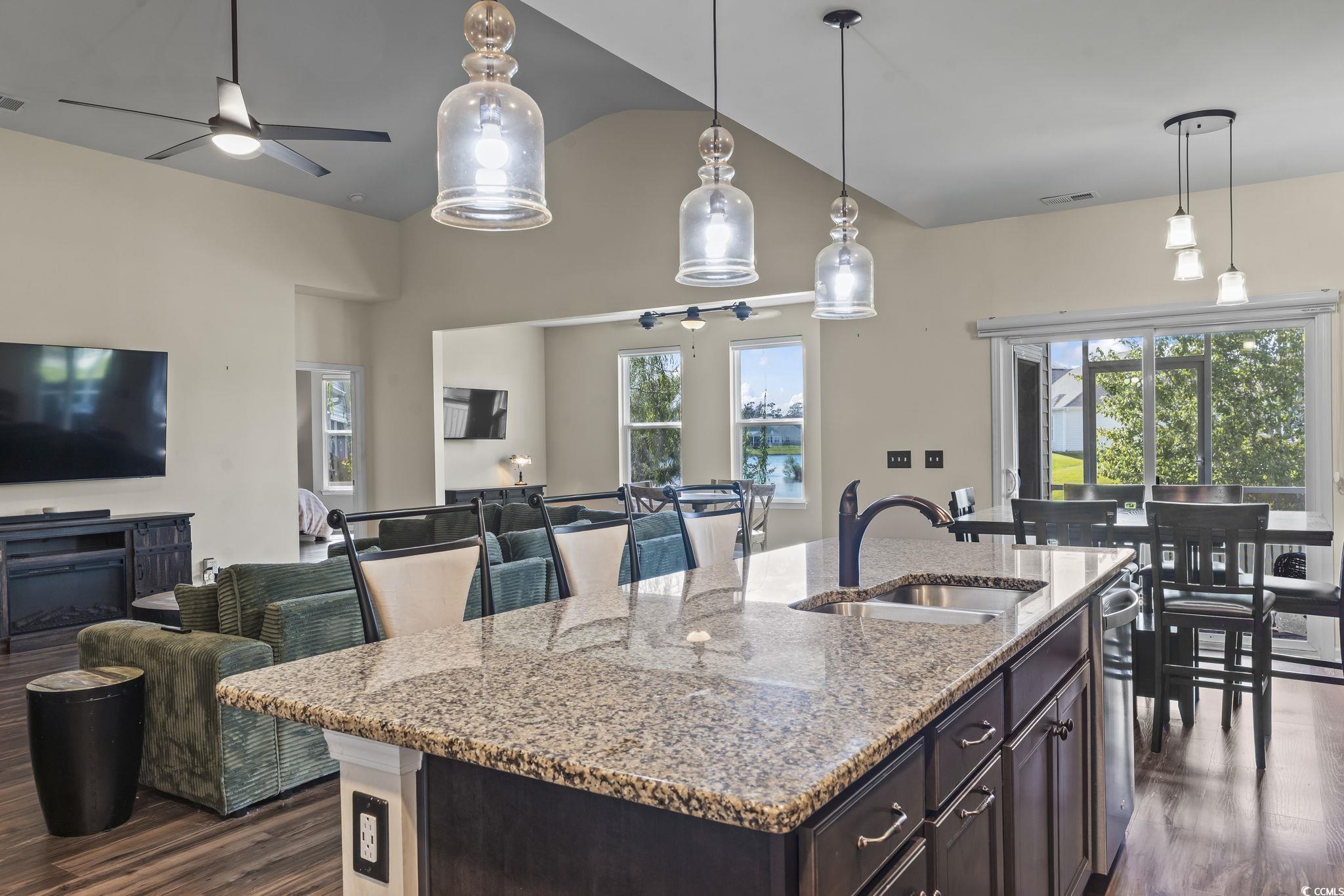 256 Copper Leaf Drive Myrtle Beach, SC 29588 - Photo 39 of 40 Kitchen with dark brown cabinets, dark wood-type flooring, decorative light fixtures, open floor plan, and vaulted ceiling