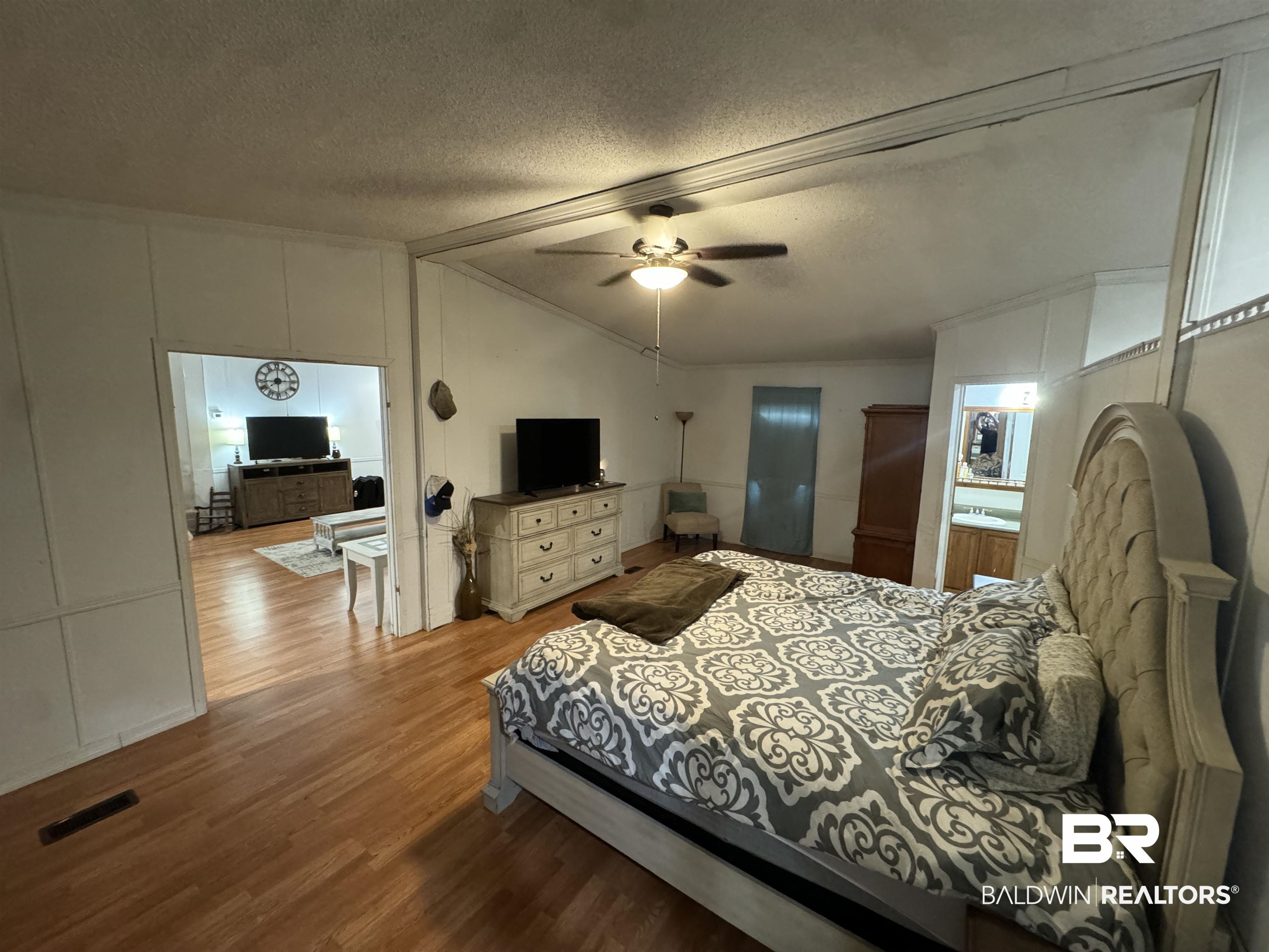 51235 Phillipsville Road Bay Minette, AL 36507 - Photo 27 of 63 Bedroom featuring dark wood-style floors, a decorative wall, and ceiling fan