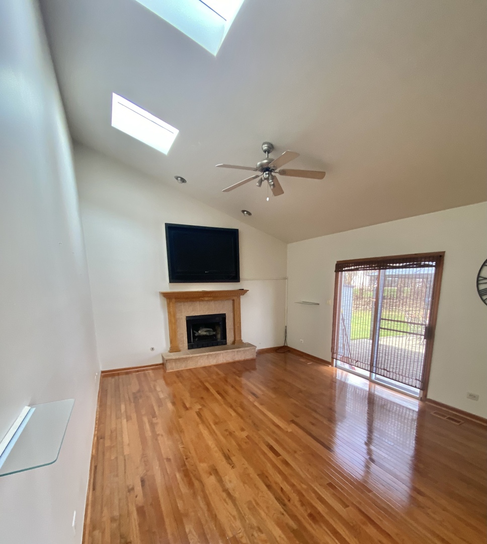 68 White Oaks Road Matteson, IL 60443 - Photo 21 of 39 an empty room with windows fireplace and wooden floor