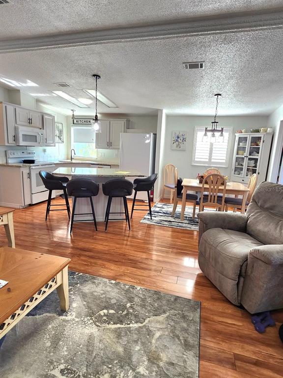 6513 Oregon Street Bradenton, FL 34207 - Photo 14 of 57 a living room with furniture a dining table and chairs with wooden floor