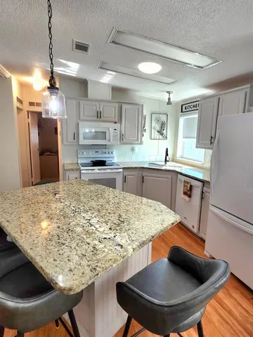 a kitchen with stainless steel appliances granite countertop a sink stove and cabinets