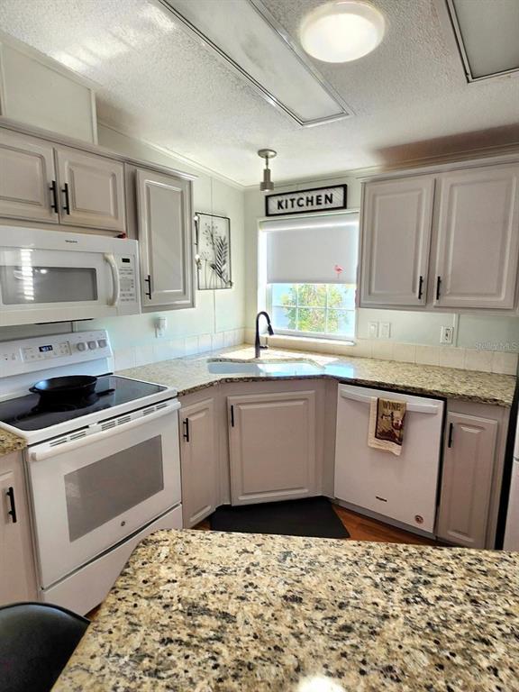 6513 Oregon Street Bradenton, FL 34207 - Photo 20 of 57 a kitchen with stainless steel appliances granite countertop a sink stove and cabinets