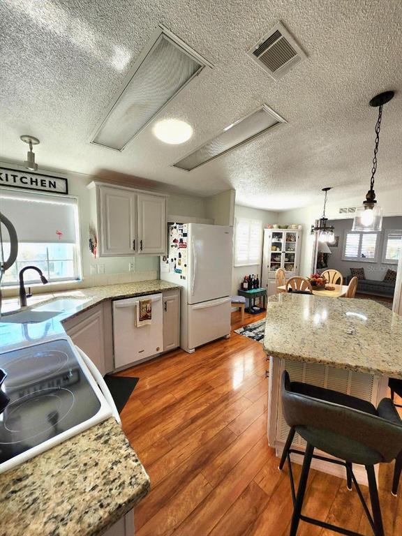6513 Oregon Street Bradenton, FL 34207 - Photo 22 of 57 a kitchen with stainless steel appliances granite countertop a sink counter space and wooden floors