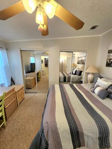 a bedroom with a bed a couch and a chandelier