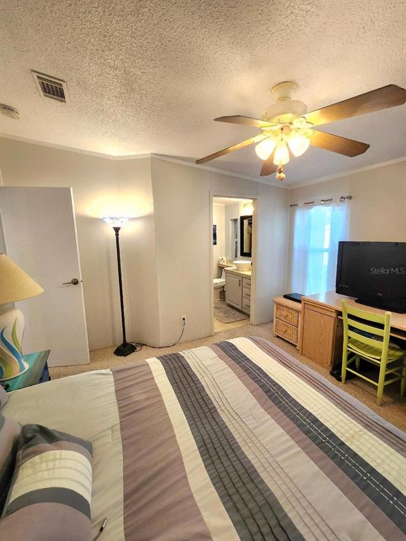 6513 Oregon Street Bradenton, FL 34207 - Photo 25 of 57 a bedroom with a bed a couch and a chandelier