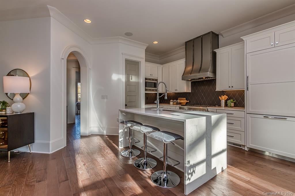 744 Ellsworth Road, Unit 46 Charlotte, NC 28211 - Photo 11 of 31 a kitchen with stainless steel appliances granite countertop a refrigerator a sink a stove and white cabinets with wooden floor