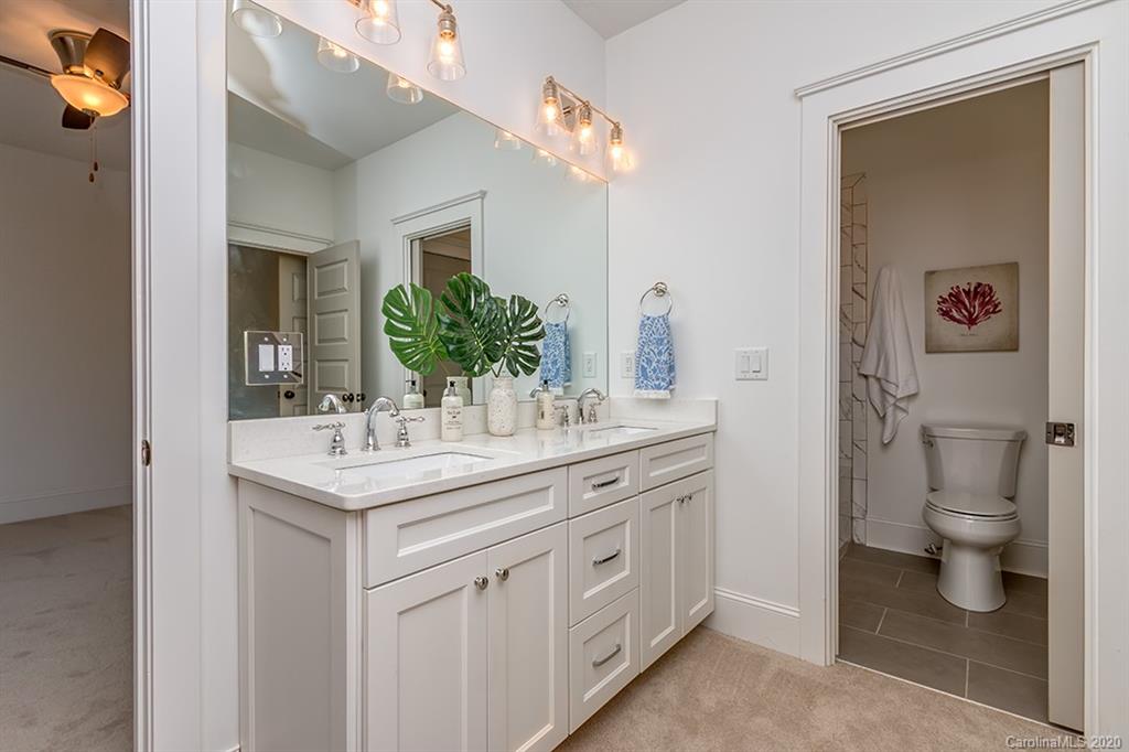 744 Ellsworth Road, Unit 46 Charlotte, NC 28211 - Photo 20 of 31 a bathroom with a granite countertop sink a toilet and a mirror