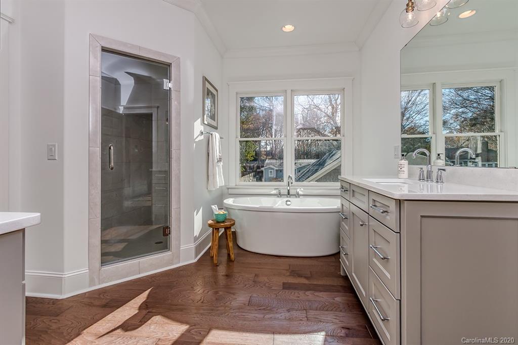 744 Ellsworth Road, Unit 46 Charlotte, NC 28211 - Photo 23 of 31 a bathroom with a double vanity sink a mirror and a bathtub