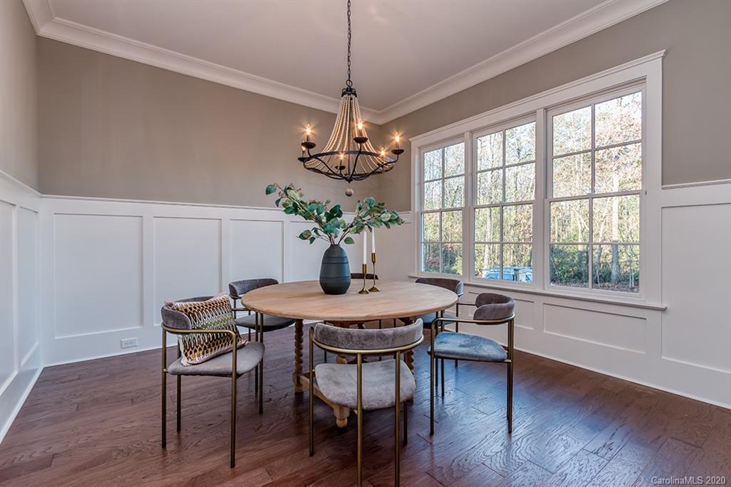 744 Ellsworth Road, Unit 46 Charlotte, NC 28211 - Photo 5 of 31 a dining room with wooden floor a chandelier a wooden table and chairs