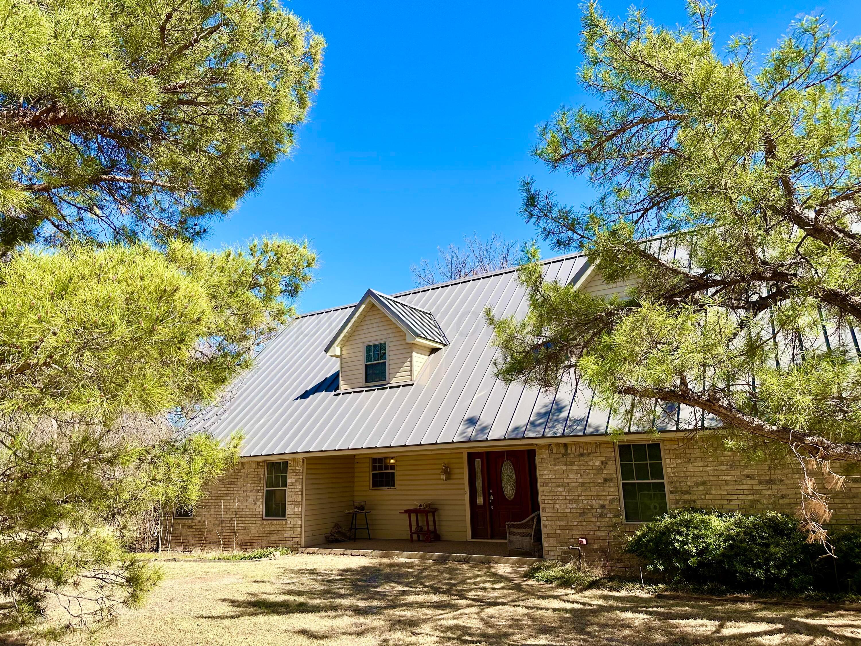 a front view of a house with a tree