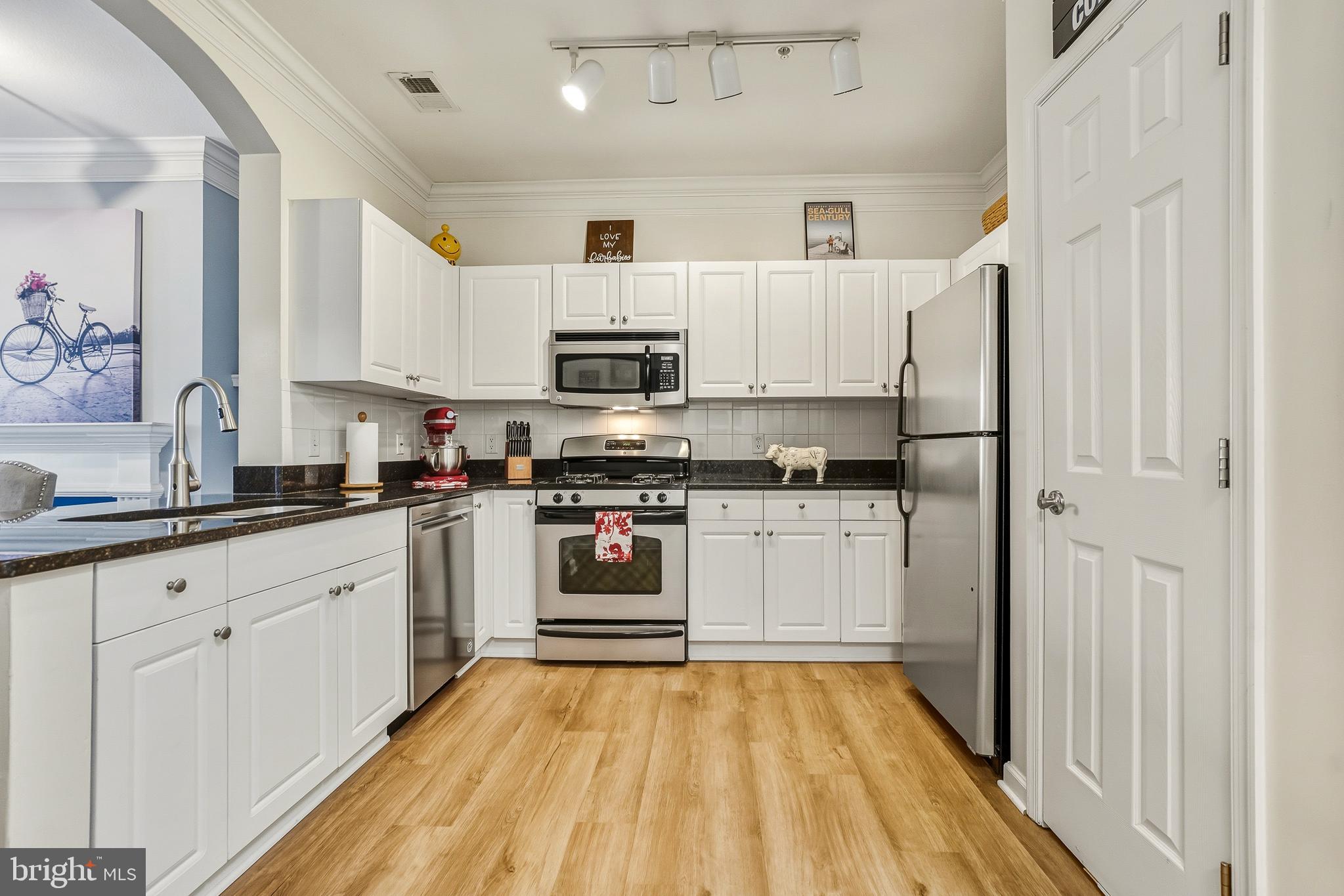 27 Booth Street, Unit 345 Gaithersburg, MD 20878 - Photo 6 of 40 a kitchen with stainless steel appliances white cabinets and a refrigerator