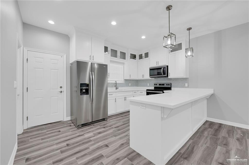 1318 San Vicente, Unit 4 Weslaco, TX 78596 - Photo 2 of 9 a kitchen with stainless steel appliances granite countertop a refrigerator a stove oven a sink dishwasher and a refrigerator with wooden floor