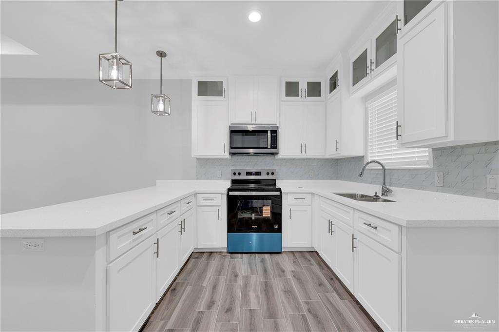 1318 San Vicente, Unit 4 Weslaco, TX 78596 - Photo 5 of 9 a kitchen with granite countertop white cabinets and stainless steel appliances