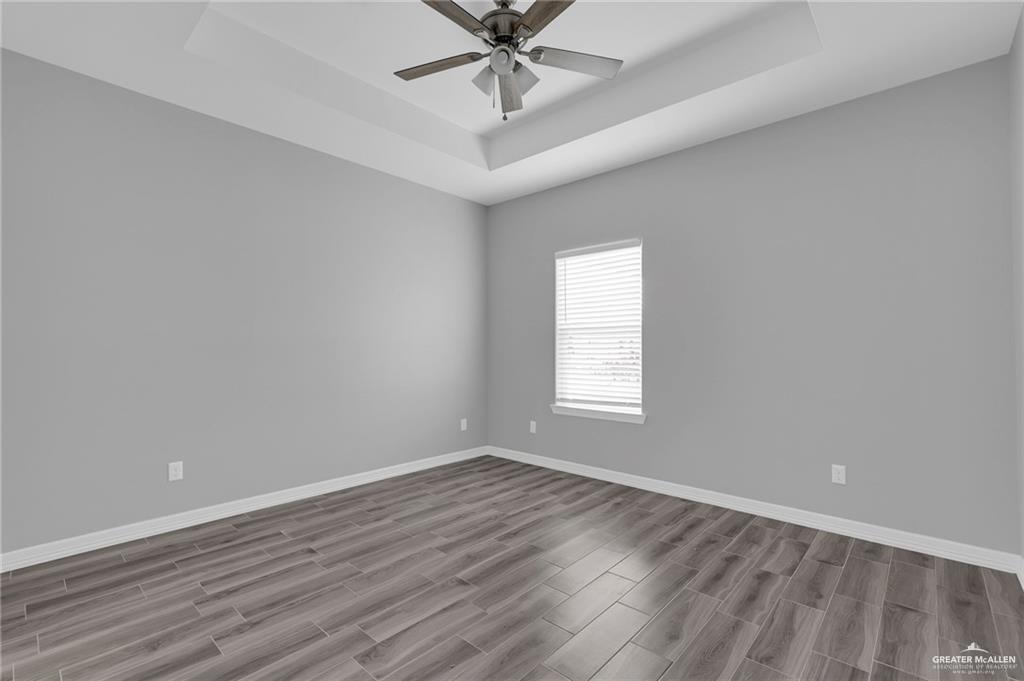 1318 San Vicente, Unit 4 Weslaco, TX 78596 - Photo 7 of 9 wooden floor in an empty room with a window
