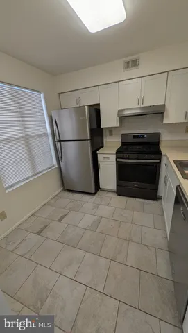 a kitchen with stainless steel appliances a stove a refrigerator and cabinets