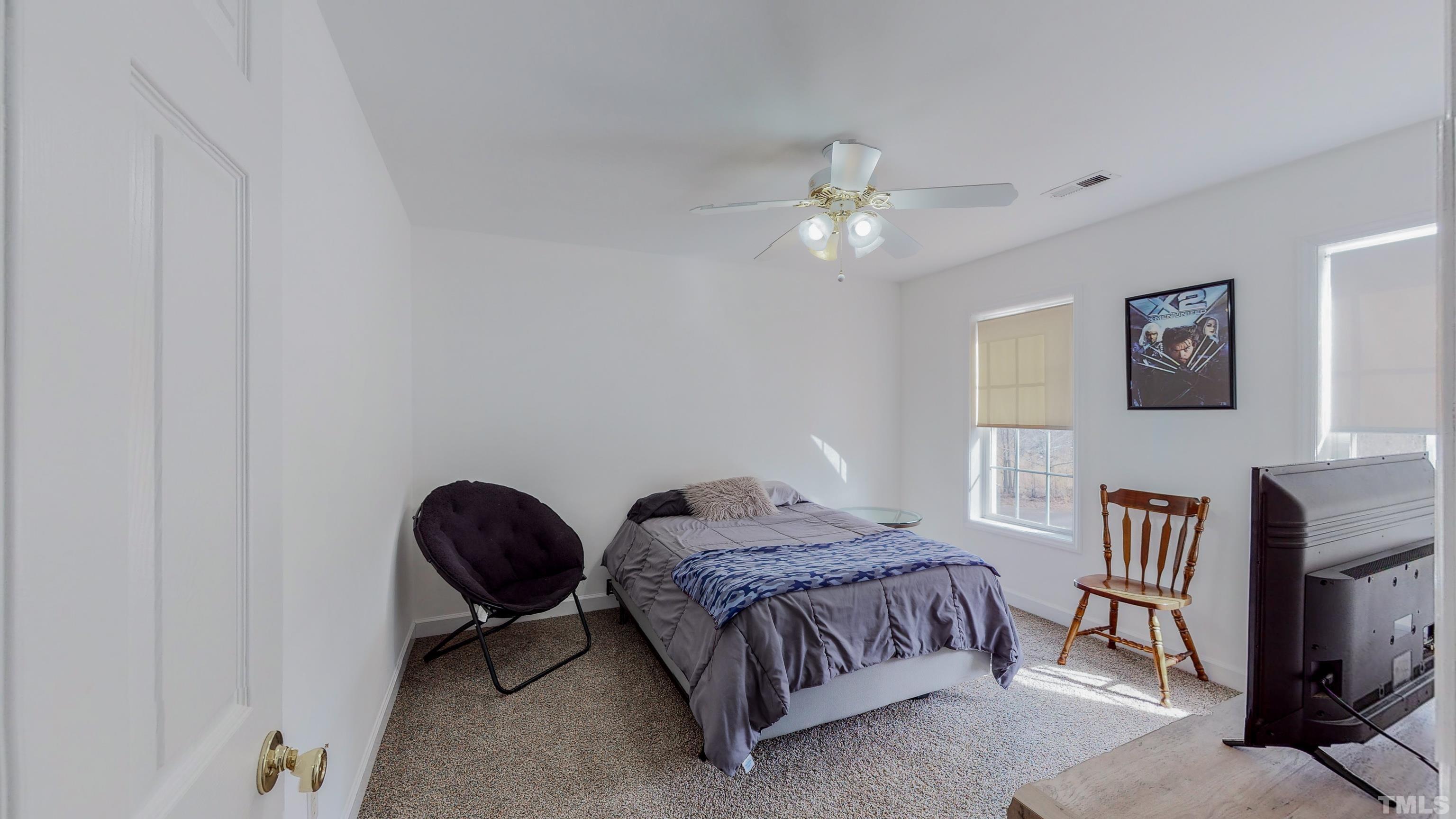 145 Deep Creek Point Rougemont, NC 27572 - Photo 31 of 52 a spacious bedroom with a bed chandelier and a window