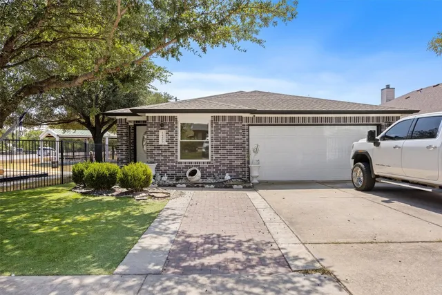 a front view of a house with a garden and yard