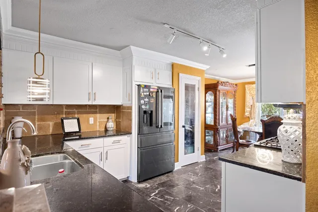 a kitchen with stainless steel appliances a stove a sink and a refrigerator