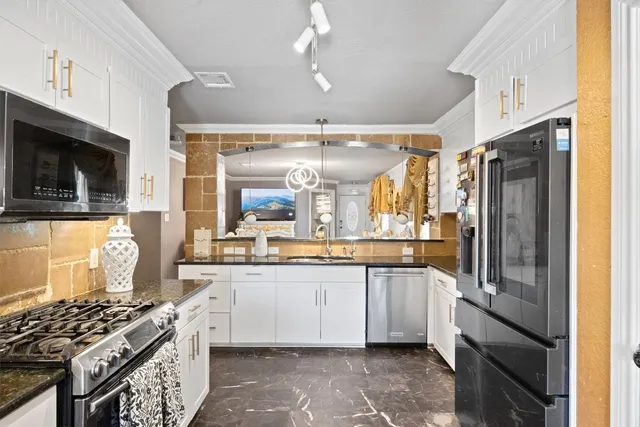 a kitchen with stainless steel appliances granite countertop a stove a sink and a microwave