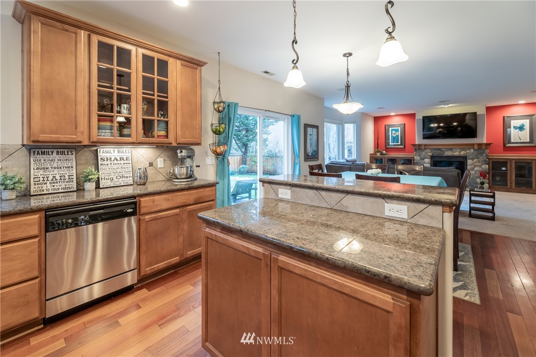 5225 Northeast 8th Place Renton, WA 98059 - Photo 14 of 38 a kitchen with stainless steel appliances granite countertop a sink stove and wooden cabinets
