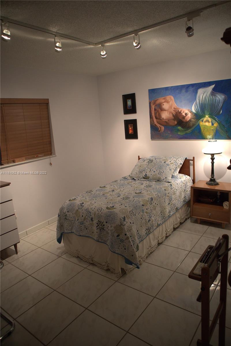 8625 Northwest 8th Street, Unit 420 Miami, FL 33126 - Photo 12 of 26 a bedroom with a bed and a flat screen tv