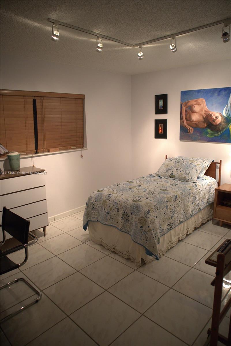 8625 Northwest 8th Street, Unit 420 Miami, FL 33126 - Photo 13 of 26 a bedroom with a bed and a cabinets