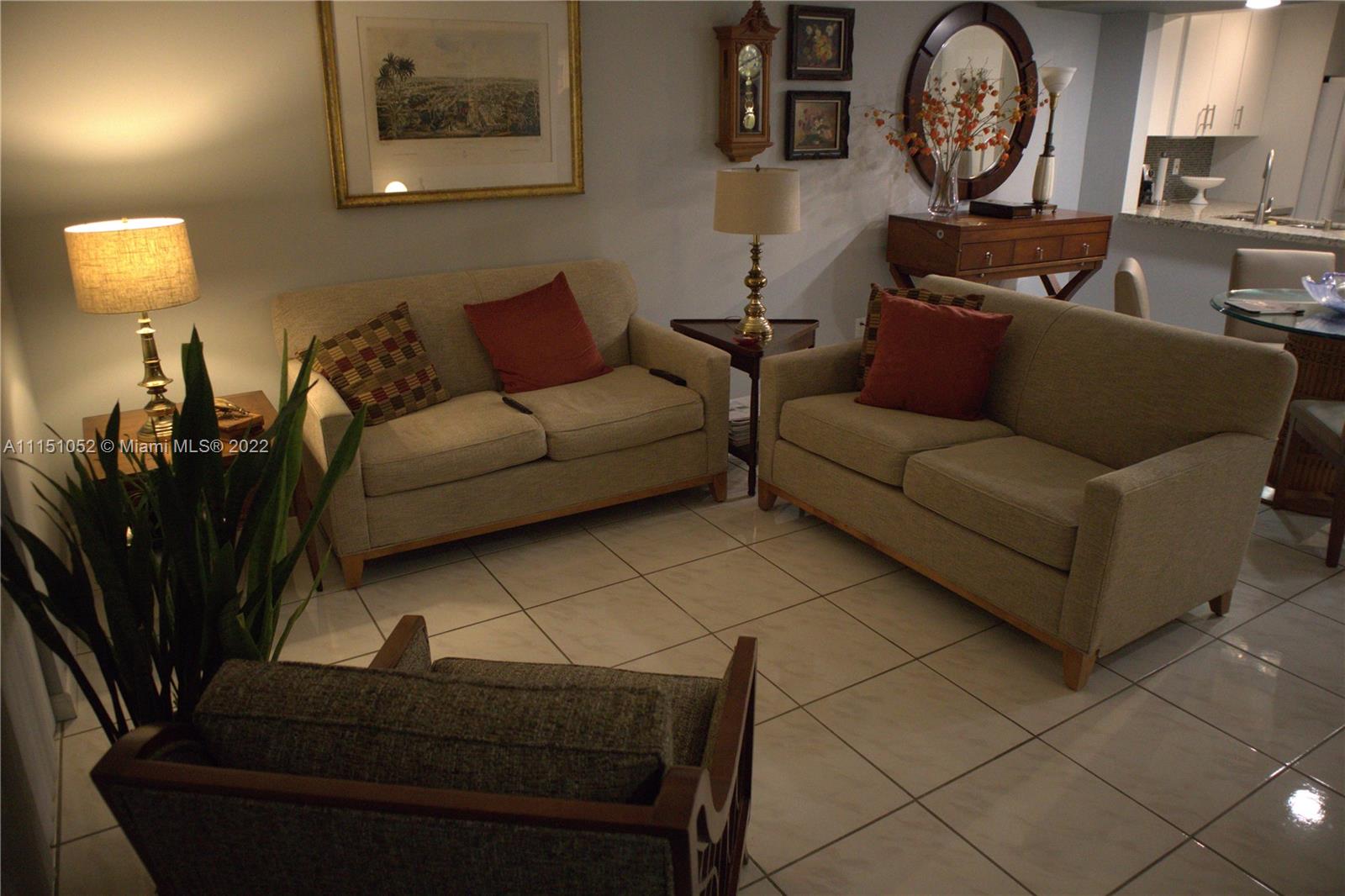 8625 Northwest 8th Street, Unit 420 Miami, FL 33126 - Photo 4 of 26 a living room with furniture and a clock