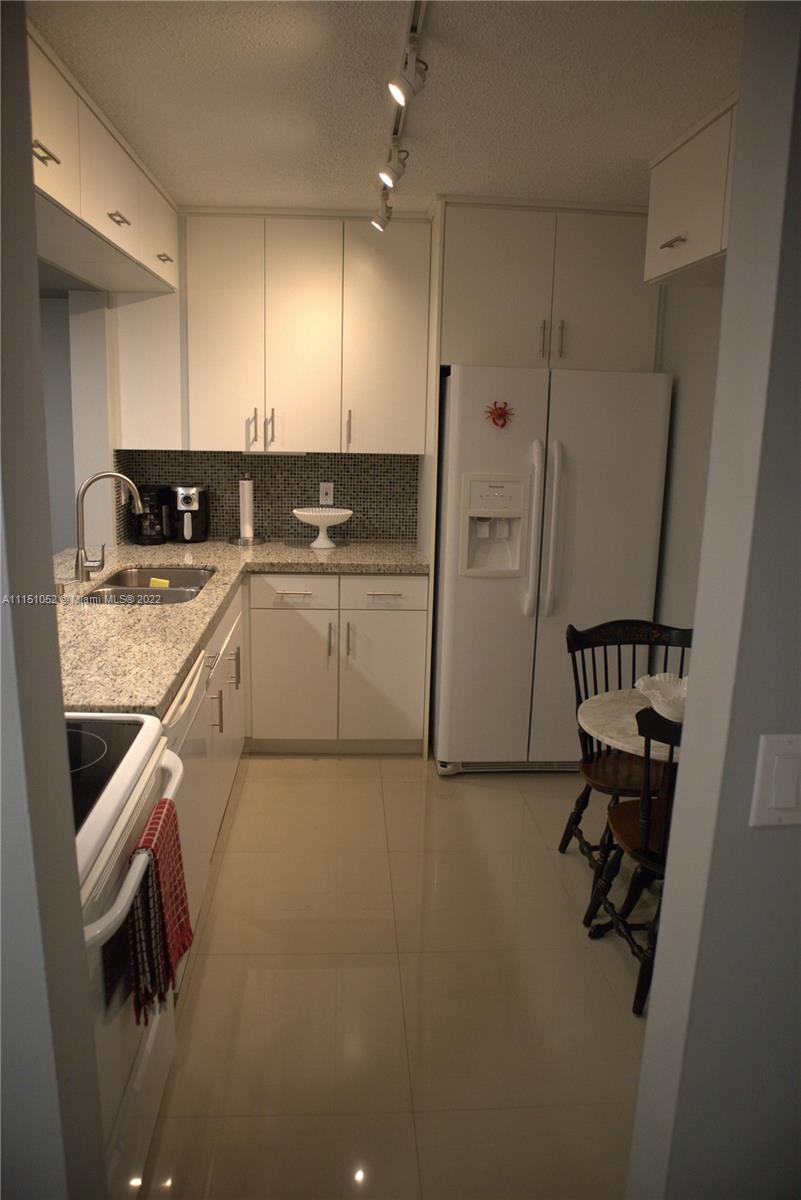 8625 Northwest 8th Street, Unit 420 Miami, FL 33126 - Photo 6 of 26 a kitchen with a sink appliances and cabinets