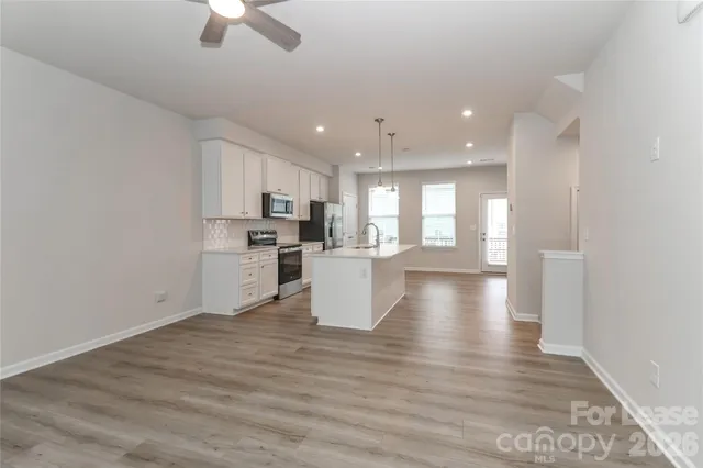 a kitchen with stainless steel appliances granite countertop a sink a stove and microwave