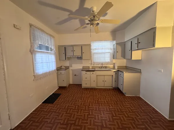 a kitchen with a sink a stove cabinets and counter space