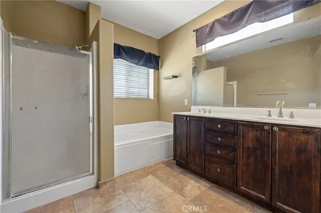 a bathroom with a tub sink vanity granite and mirror